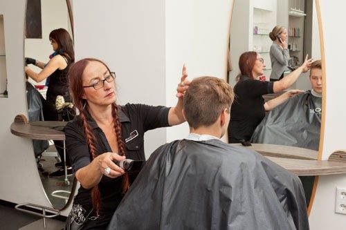 Friseurin schneidet einem Kunden die Haare
